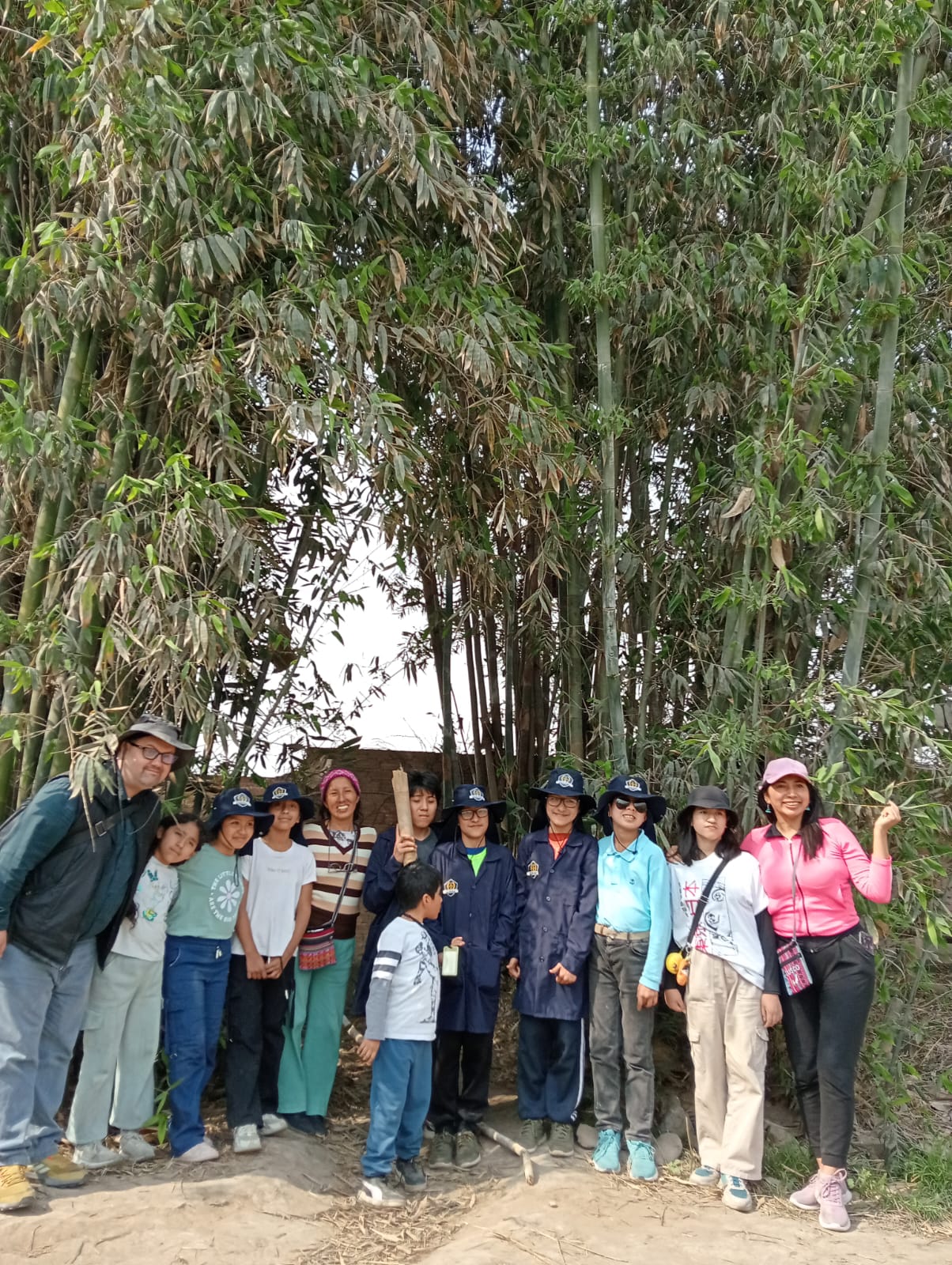 Grupo de visitantes reunido junto a los bambúes del fundo