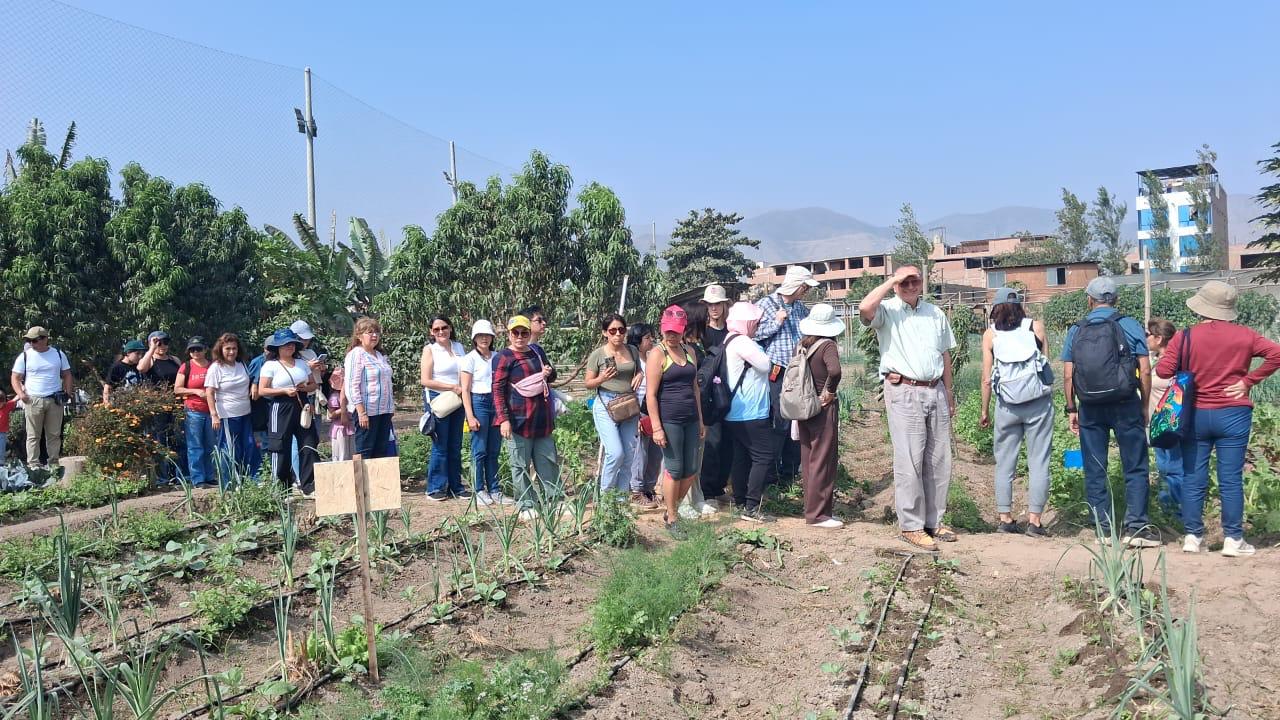 Grupo de visitantes recorriendo los senderos del huerto