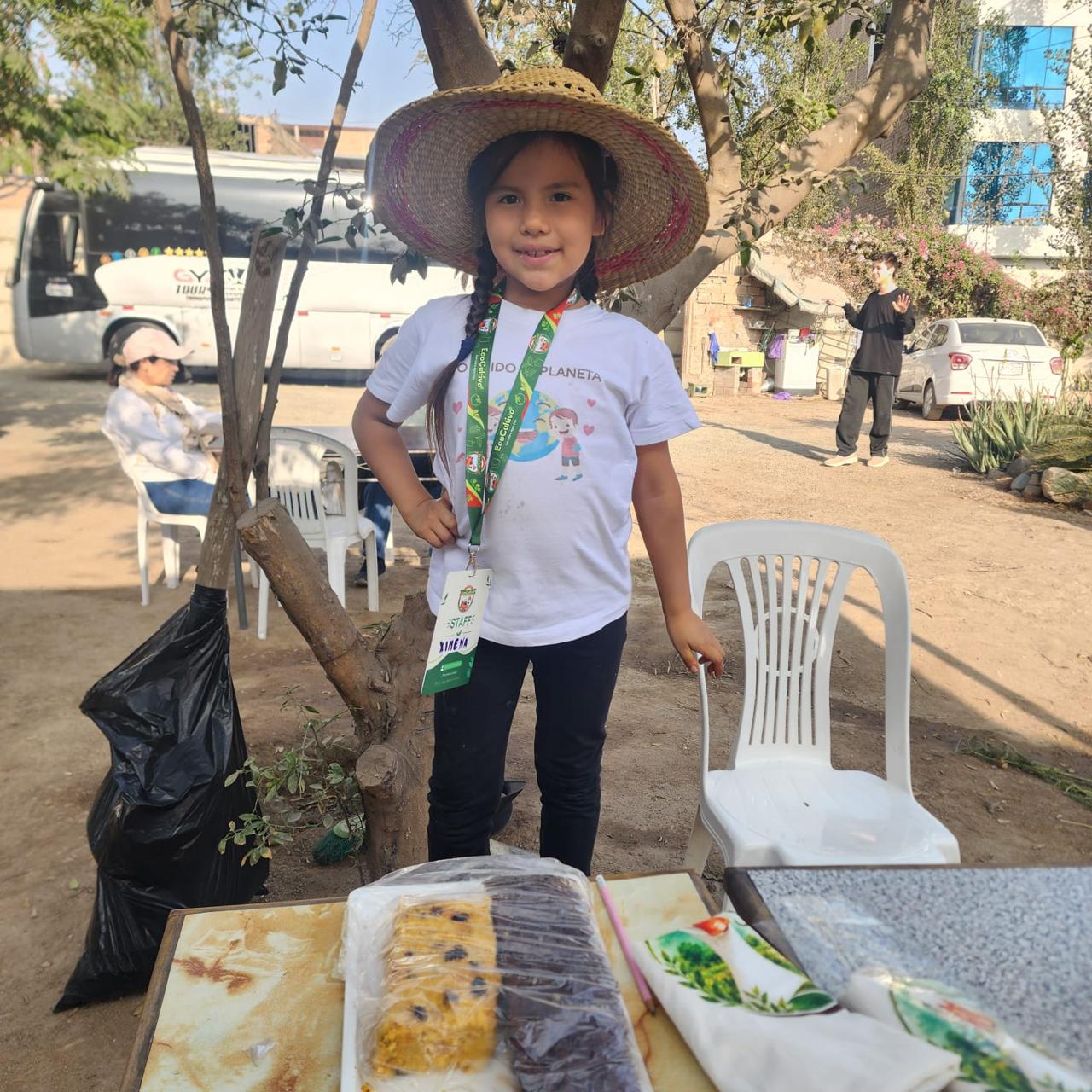 Niña con sombrero junto a una mesa durante un encuentro en el fundo